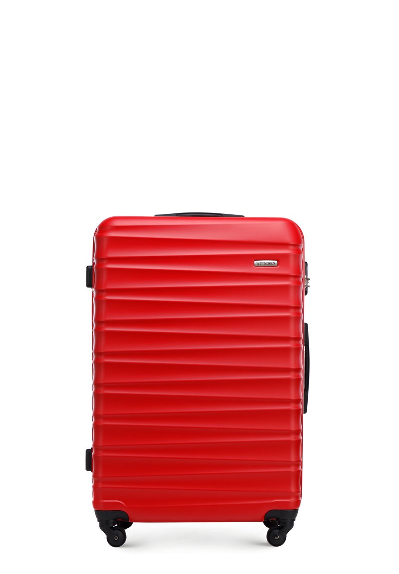 Valise rigide rouge avec des rainures horizontales, accents noirs et quatre roues. Équipée d'une poignée télescopique et d'un cadenas à combinaison.