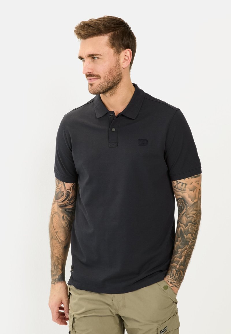 Sort polo-skjorte med korte ærmer, to-knaps stolpe og broderet logo på brystet, lavet af glat, åndbart materiale.