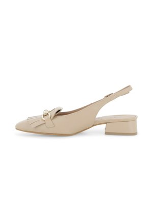 Scarpa slingback in pelle beige con tacco basso a blocco, punta appuntita, dettaglio con frange e fibbia circolare metallica su sfondo bianco.