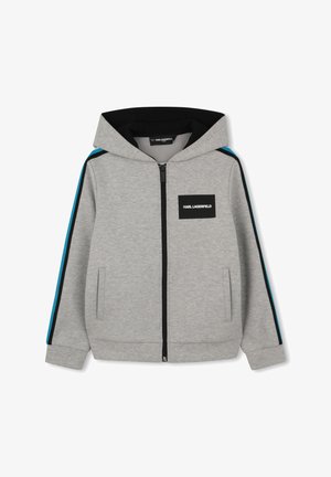 Grijze capuchonjack met rits, met zwarte en blauwe strepen op de mouwen en een zwart rechthoekig logoplaatje met de tekst "KARL LAGERFELD" op de borst.