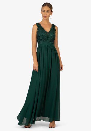 Langdonkergroene jurk met een kanten lijfje, V-halslijn en een vloeiende chiffon rok. Heeft brede schouderbanden en een geplooide taille.