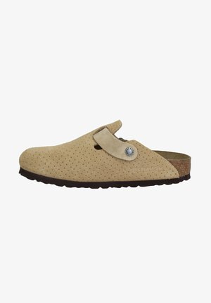 Beige Wildleder-Slipper mit durchbrochenem Design, Korkfußbett, verstellbarem Riemen und dunkler Gummisohle. Mit einem Metalllogo-Akzent.