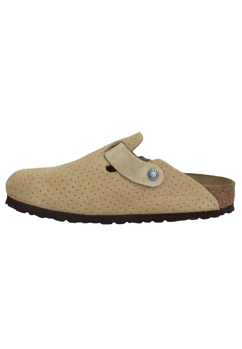 Sabots en suède beige à enfiler avec un design perforé, semelle en liège, sangle réglable et semelle en caoutchouc foncé. Avec un accent en métal logo.