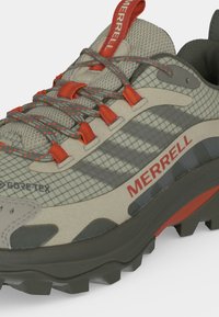 Γκρι και πορτοκαλί ορειβατικό παπούτσι Merrell με επάνω μέρος από δίχτυ Gore-Tex, κορδόνια με σχέδιο και ανθεκτική μαύρη σόλα για εξωτερική χρήση.