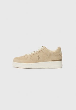 Beige lav sko i semsket skinn med hvite snører, med side logo, perforeringer på tåboksen og en teksturert gummisåle.