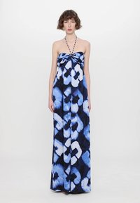 Robe maxi à motif tie-dye bleu, dotée d'un design sans épaules avec un devant noué, un tissu fluide et une silhouette longue jusqu'aux chevilles.