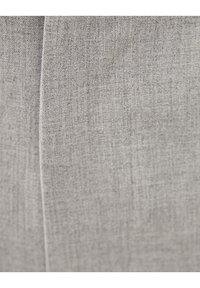 Gros plan sur un tissu gris clair, présentant un tissage texturé avec de subtiles variations. Surface lisse avec un léger éclat et sans motifs visibles.