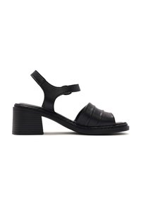 Black leather sandal with a block heel, featuring a wide strap across the front and adjustable ankle strap. Textured finish and stitching details.