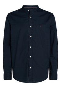 Camisa azul marino abotonada con cuello mao, mangas largas y botones blancos; presenta un pequeño logotipo en el pecho. Tejido de algodón.