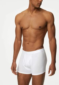 Weiße Baumwoll-Boxershorts mit einem elastischen, weichen Bund, ausgestattet mit einem funktionalen Eingriff und einer engen Passform für hohen Tragekomfort. Sichtbare Struktur des Stoffs.