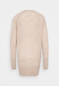 Beżowy dziergany sweter o luźnym, oversize'owym kroju. Posiada długie rękawy, okrągły dekolt oraz subtelny, fakturowany wzór.