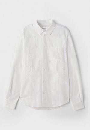 White button-up shirt features a classic collar, long sleeves, and embroidered lace accents on shoulders and pocket. Soft fabric texture.