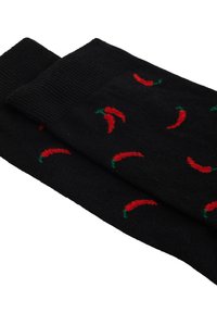 Calcetines negros con motivos de chiles rojos y acentos verdes. La tela parece suave y cuenta con un puño acanalado para un ajuste seguro.