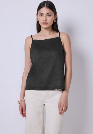 Camisole en lin noir avec des bretelles fines et un décolleté droit, associée à un pantalon large blanc. Texture lisse et coupe décontractée.