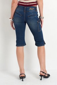 Niebieskie dżinsowe spodnie capri z dwiema tylkimi kieszeniami i bocznymi kieszeniami cargo. Zniszczone akcenty i detal w postaci przeszytego dołu.