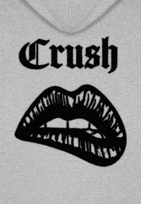Felpa grigia con la parola "Crush" in grassetto nero sopra un design stilizzato di labbra nere con contorni e texture ben definiti.