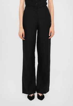 Black wide-leg trousers made of lightweight fabric, featuring a high waist and clean lines, paired with pointed black shoes.