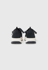 Black suede and mesh sneakers with cream midsoles and black rubber outsoles. Features black patterned laces and embossed logo on heels.