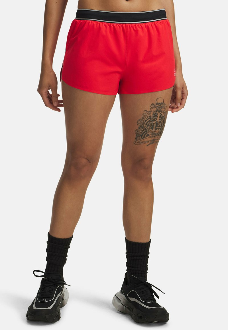 Pantalones cortos deportivos rojos con una cinturilla elástica negra, con una textura suave y una longitud hasta el muslo, combinados con calzado y calcetines negros.