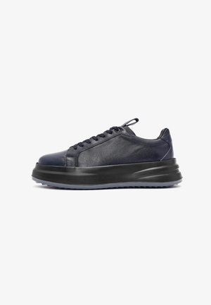 Sneaker in pelle blu con un design low-top elegante, suola nera spessa, tomaia testurizzata e lacci tonali. Branding discreto e accenti minimali.