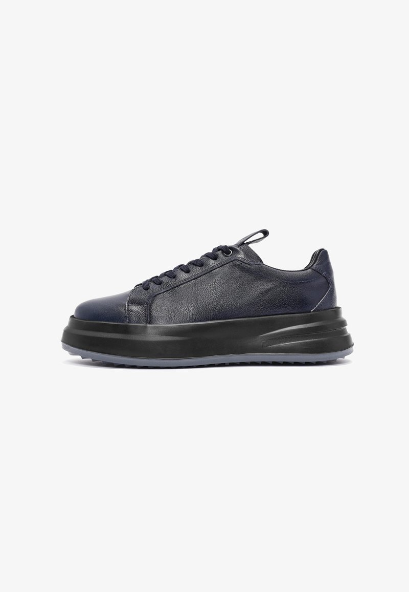 Granatowe skórzane sneakersy o smukłym, niskim kroju, z grubą czarną podeszwą, teksturowanym wierzchem i tonowymi sznurowadłami. Subtelne logo i minimalne akcenty.