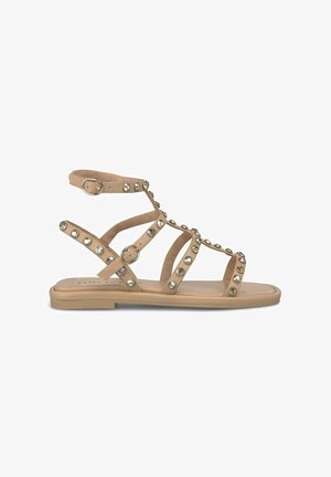 Sandale plate bej cu multiple curele încrucișate, decorate cu puncte rotunde, având cataramă ajustabilă la gleznă și talpă netedă.