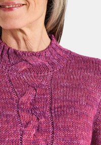 Strickpullover in Schattierungen von Rosa und Lila, mit einem strukturierten Kabeldesign und einem hohen Kragen. Weiches Material mit kunstvollen Nähte-Details.