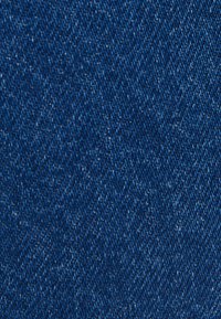 Tela de mezclilla azul profundo con una textura suave, que presenta un patrón clásico de sarga y sutiles destellos de luz a lo largo.