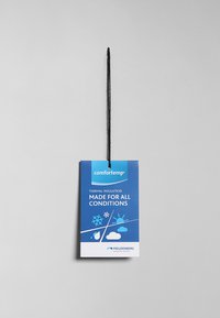 Blå produktetikett med svart snöre, märkt "comfortemp", framhäver "termisk isolering" och "gjord för alla förhållanden" med väderikoner.
