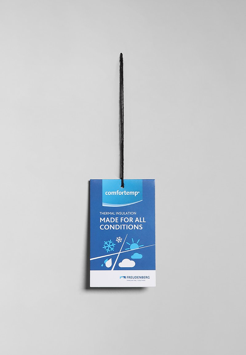 Niebieska metka produktu z czarnym sznurkiem, oznaczona napisem "comfortemp", podkreślająca "izolację termiczną" oraz "stworzone do wszelkich warunków" z ikonami przedstawiającymi pogodę.