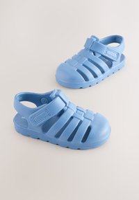 Sandales en caoutchouc bleu avec une bride et des côtés ouverts ; présentent une surface texturée et plusieurs fentes de ventilation pour la respirabilité.