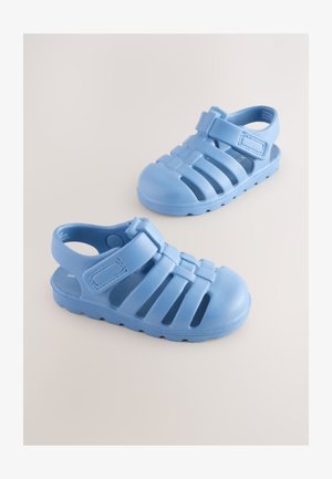 Niebieskie gumowe sandały z paskiem i otwartymi bokami; posiadają teksturowaną powierzchnię oraz liczne otwory wentylacyjne zapewniające przewiewność.