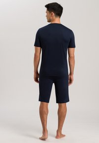 Navyblaues T-Shirt mit kurzen Ärmeln und knie-langen Shorts aus weichem Stoff, mit lässiger Passform und minimalistischem Design, schlicht ohne Muster.