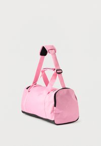 Rózsaszín nejlon sporttáska fekete aljjal, dupla fogantyúval és állítható vállpánttal. Simább textúra, lekerekített forma cipzáras záródással.