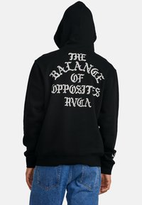 Schwarzer Hoodie mit weißem Text "THE BALANCE OF OPPOSITS RVCA" auf dem Rücken, mit entspannter Passform und weichem Stoff.