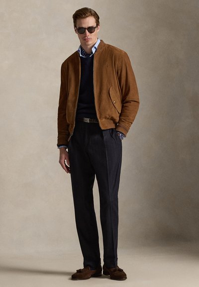 Καφέ σαμουά μπομπέρ μπουφάν, ναυτικό πουλόβερ, μπλε πουκάμισο με πουά σχέδιο, παντελόνια με ρίγες, και καφέ λοφτς. Μαύρα γυαλιά ηλίου ολοκληρώνουν την εμφάνιση.