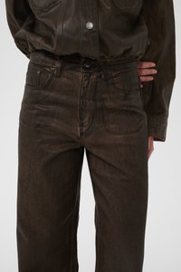 Barna farmernadrág egyenes szárú szabással, klasszikus ötpocketes kialakítással és finom textúravariációkkal. Gombos záródás.