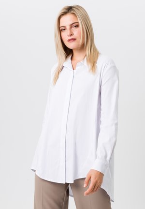 White long-sleeve shirt with a button-down collar, relaxed fit, and side slits. Made of smooth fabric, featuring a classic design.