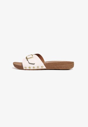 White slide sandal with a cork sole, featuring a prominent golden buckle accent and decorative gold stud details along the strap.