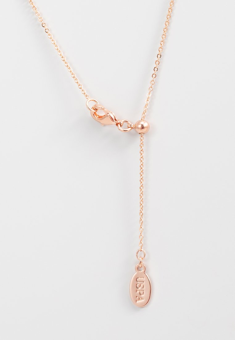 Halskette aus Roségold mit einer dünnen Kette, die einen Verschluss und eine runde Akzentperle aufweist. Enthält ein kleines ovales Tag mit der Gravur "USPA".
