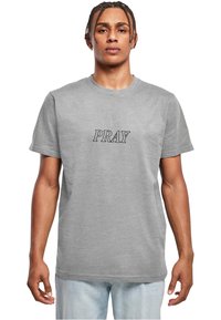 Siva bombažna majica s kratkimi rokavi, ki ima na prsih izšito besedo "PRAY" v črni barvi. Klasičen kroj, gladka tekstura.