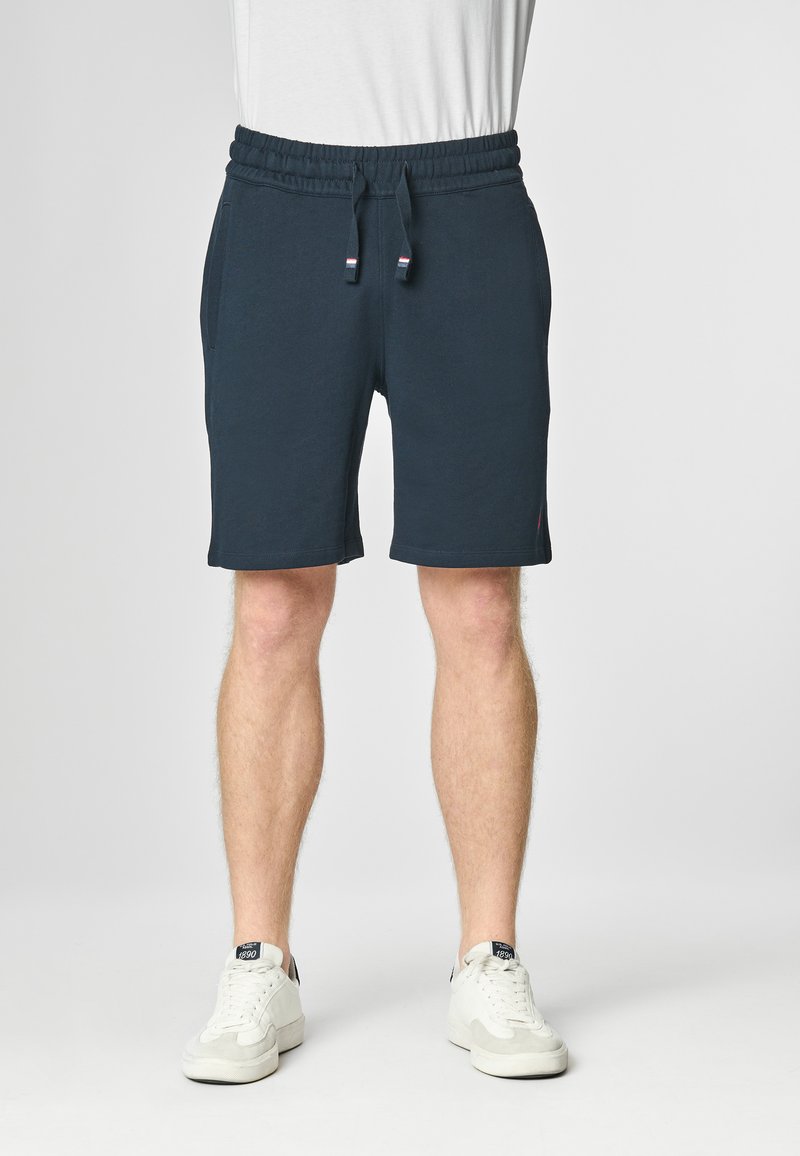 Pantaloni corti in cotone blu navy con vita elastica, cordino e tasche laterali. Presentano un piccolo logo vicino all'orlo.