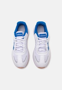 Baskets blanches avec des accents bleus, en matériau mesh, à bout rond et semelle en caoutchouc. Elles présentent des lacets et un logo Adidas sur la languette.