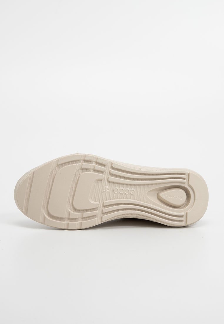 Jasnobeżowa podeszwa buta z teksturowanym wzorem i wypukłymi obszarami antypoślizgowymi; zawiera wytłoczone logo na środkowej części podeszwy. Gładki materiał gumowy.