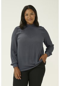 Blusa grigio scuro con maniche lunghe, scollatura arricciata, maniche plissettate e polsini con bottoni, realizzata in un tessuto leggero e morbido.
