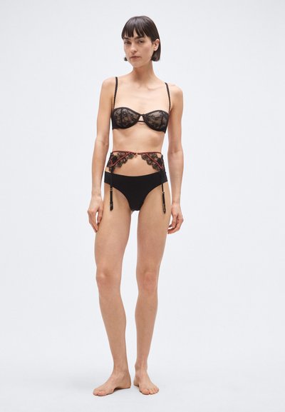 Čierny súprava spodnej bielizne so šifónovou čipkovanou podprsenkou s dekoratívnymi pásikmi a vysokými nohavičkami s čipkovými detailmi a strapcami.