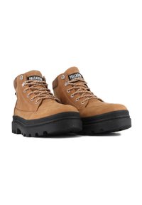 Botas de senderismo de cuero marrón con suelas de goma negra, cordones redondos, ojales de metal y un cuello acolchado. Logo de la marca visible en la lengüeta.