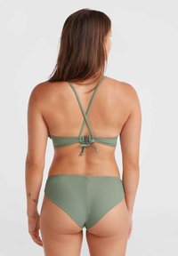 Grünes Bikini-Set mit verstellbaren Kreuzgurten und einem Rückenverschluss. Die strukturierte Badebekleidung zeichnet sich durch hochgeschnittene Unterteile und ein minimalistisches Design aus.