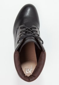 Chaussure en cuir noir avec bout arrondi, lacets et œillets métalliques. Accents en daim brun au niveau du col. Doublure intérieure lisse.