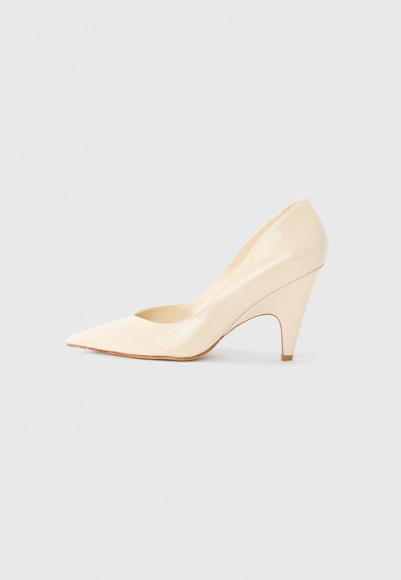 Escarpin en cuir verni beige à talon aiguille, avec un bout pointu et un talon effilé, affichant une finition lisse et brillante ainsi qu'une silhouette épurée.